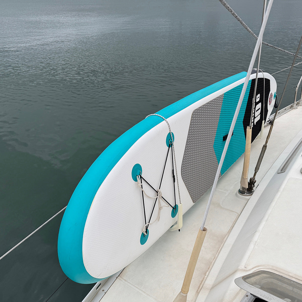 SUP board stored on inside of boat rail – paddle board holder keeping deck clear at marina