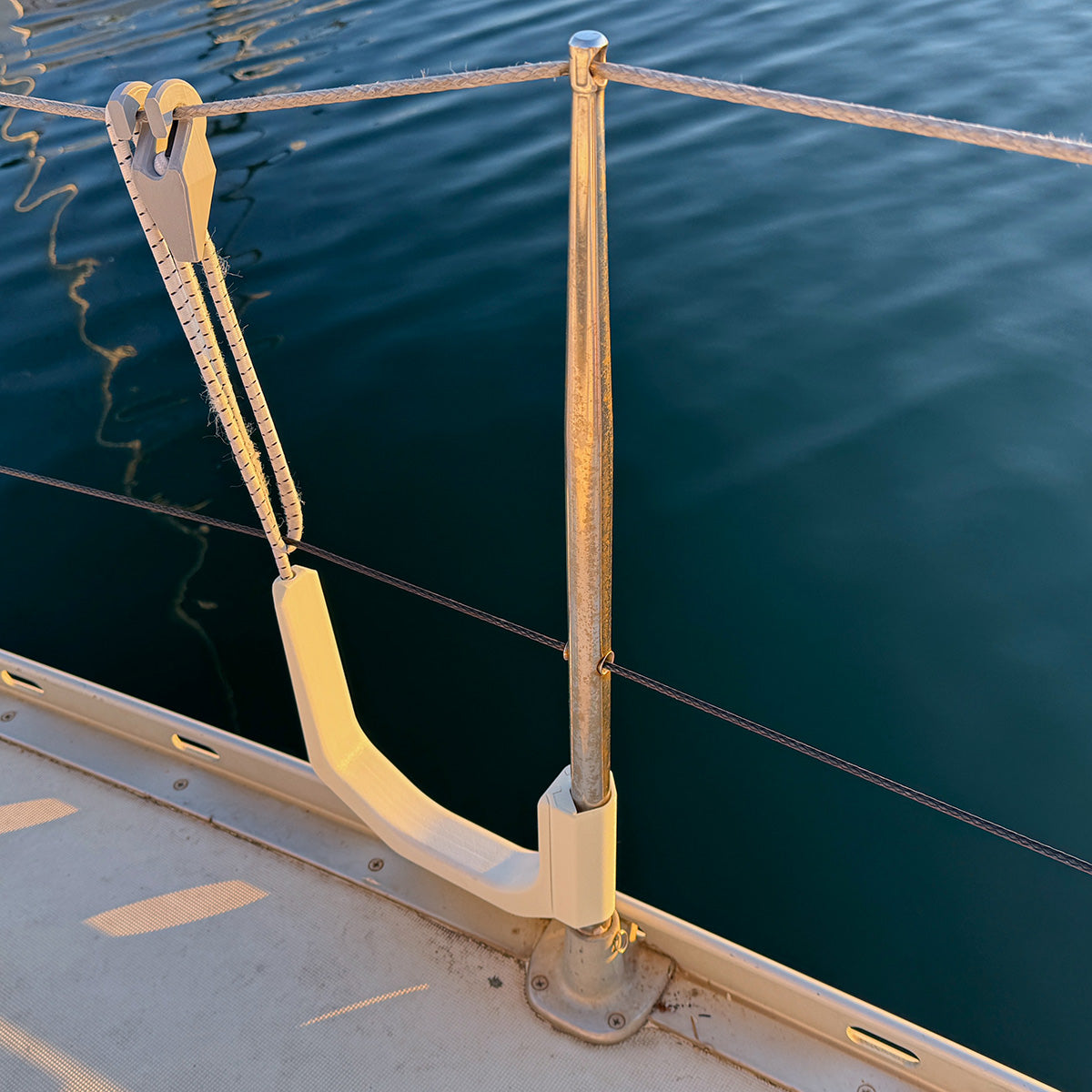 SUP board holder storing paddle board on yacht rail – marine-grade rack with rubber securing cord